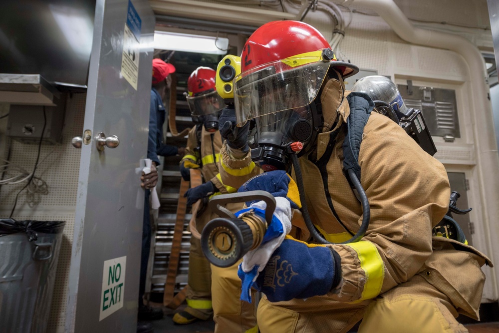 Seaman Allen Jimenez, from Dallas, Texas, fights a fake fire in the forward operations berthing on the Ticonderoga-class guided-missile cruiser USS Chancellorsville (CG 62) during a general quarters drill in support of Valiant Shield 2018