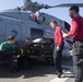 U.S. Sailors, assigned to Helicopter Maritime Strike Squadron (HSM) 71, load an AGM-114 Hellfire missile