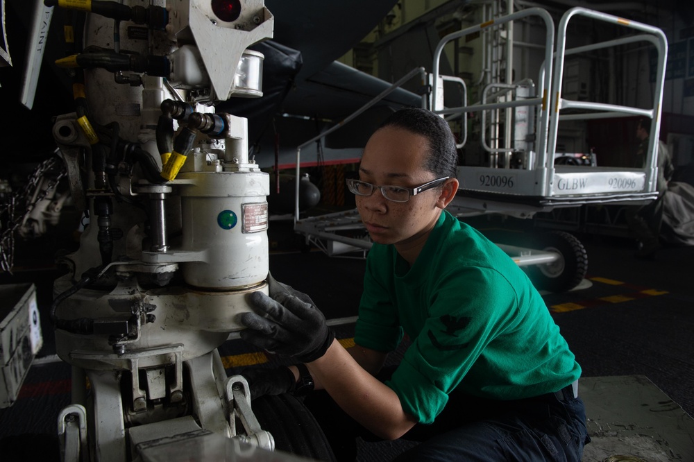 U.S. Sailor performs maintenance on landing gear