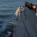 U.S. Sailors observe a flare during a man overboard drill