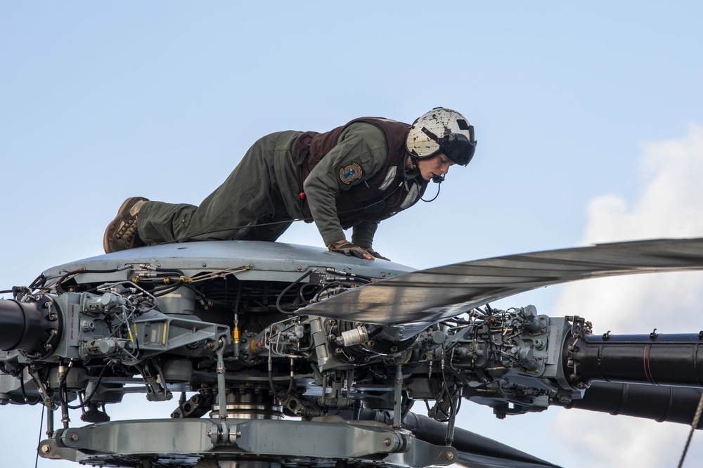 U.S. Marine inspects rotor of a CH-53E Super Stallion