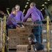 U.S. Sailors load boxes onto a conveyor aboard USS John C. Stennis