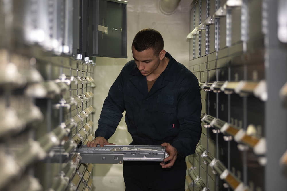 U.S. Sailor searches for supplies aboard the aircraft carrier USS John C. Stennis (CVN 74)