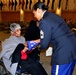 Rebecca Oduba, left, grandmother of Army Lt. Col. Thomas E. Wooden Jr., receives an American flag in honor of her grandson's retirement Jan. 4, 2018 in Philadelphia.