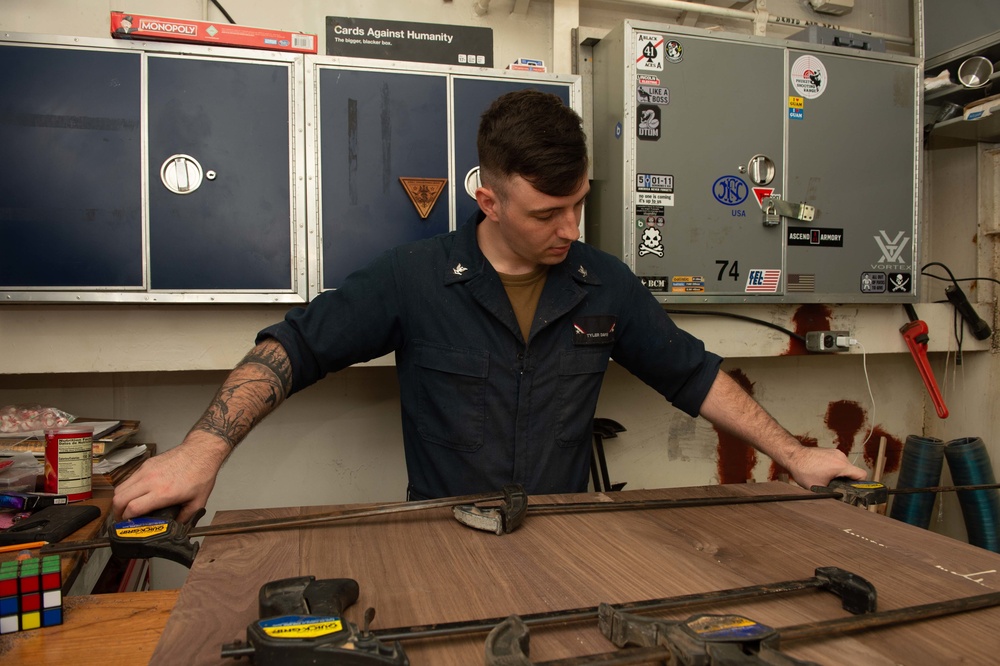U.S. Sailor uses vice grips on wood planks