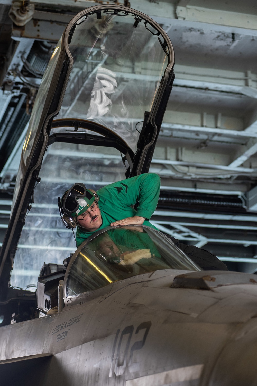 U.S. Sailor cleans the windshield of an F/A-18F Super Hornet