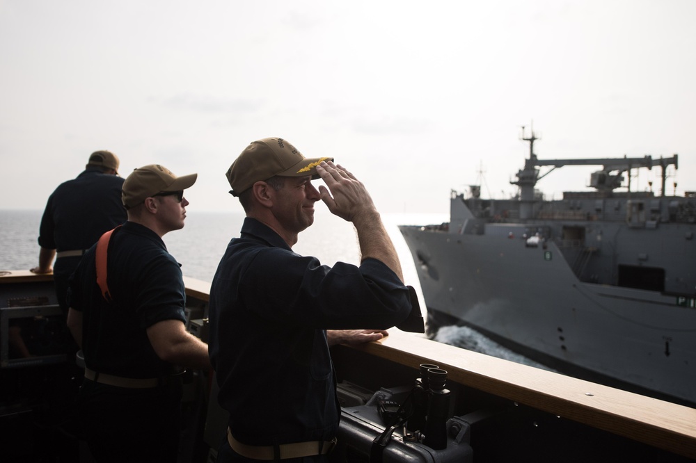 U.S. Navy Capt. Robert Bryans Jr., from Cohohes, New York, salutes to the dry cargo and ammunition ship USNS Charles Drew (T-AKE 10)