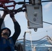 U.S. Navy Seaman Matthew Plucinski, from Roseville, Michigan, attaches a pelican hook to a sliding padeye aboard USS Chung-Hoon