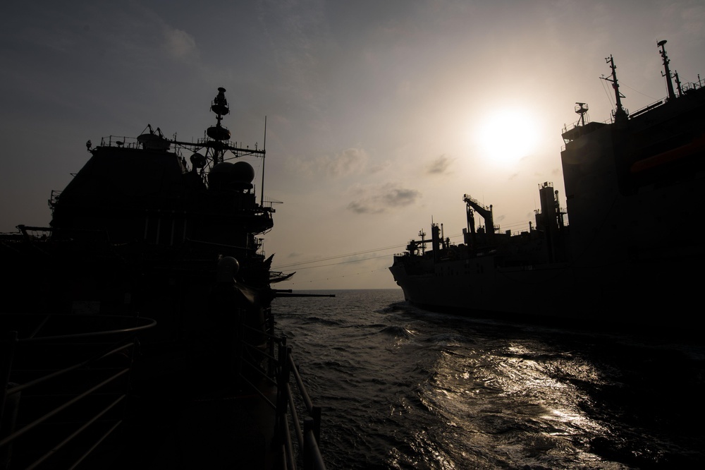 The guided-missile cruiser USS Mobile Bay (CG 53) conducts a vertical replenishment with the dry cargo and ammunition Ship USNS Charles Drew