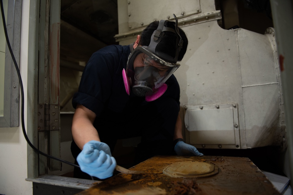 U.S. Sailor removes rust aboard the aircraft carrier USS John C. Stennis (CVN 74)