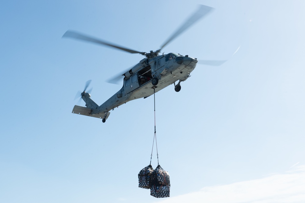 An MH-60S Knight Hawk conducts vertical replenishment