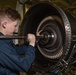 U.S. Sailor conducts maintenance on a jet engine