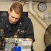 U.S. Sailor performs inspection on a bomb rack unit