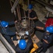 U.S. Sailors raise a jet engine