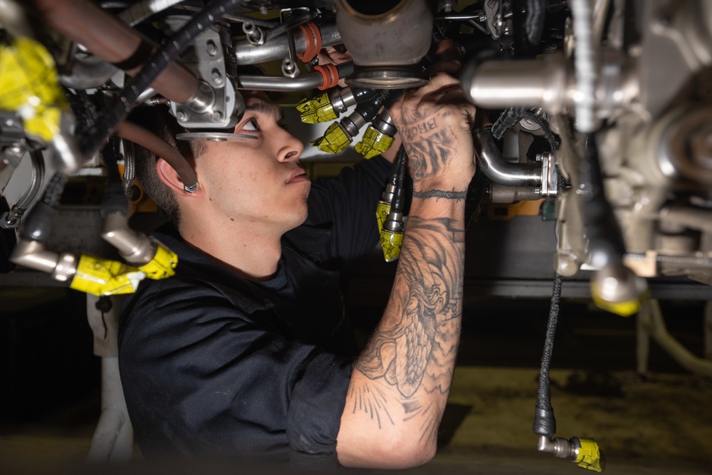 U.S. Sailor conducts maintenance on a jet engine