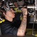 U.S. Sailor conducts maintenance on a jet engine