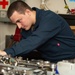 U.S. Sailor performs inspection on a bomb rack unit