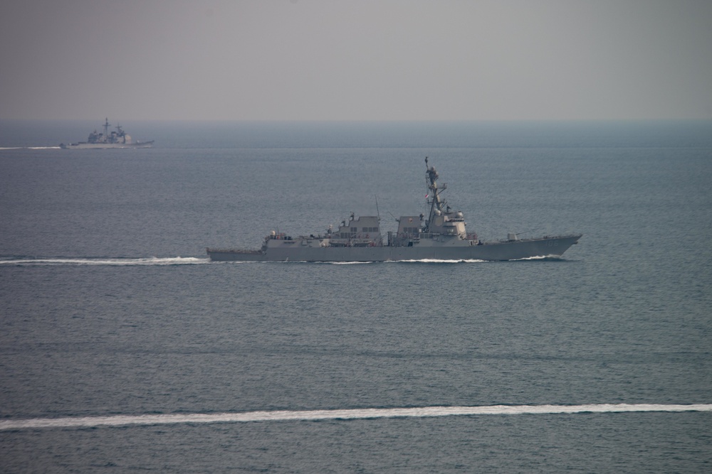 The guided-missile destroyer USS Stockdale (DDG 106) and the guided-missile cruiser USS Mobile Bay (CG 53) cut through the Arabian Gulf