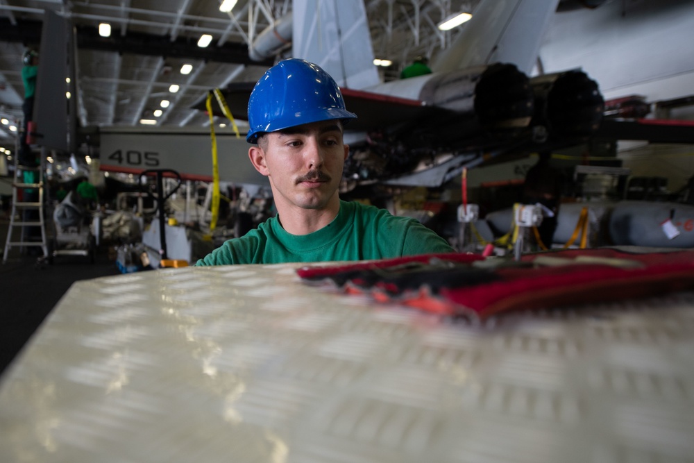 U.S. Sailor installs a intake grill on a starting unit.