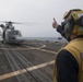 U.S. Navy Boatswain’s Mate 3rd Class Brandon Ross, from Honeapath, South Carolina, signals to the pilot of a Panther anti-submarine helicopter