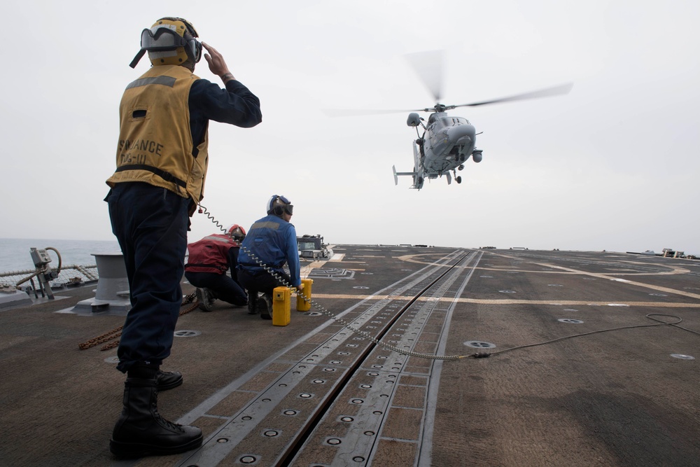 U.S. Navy Boatswain’s Mate 3rd Class Brandon Ross, from Honeapath, South Carolina, signals the pilot of a Panther anti-submarine helicopter