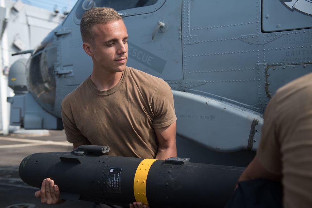 U.S. Navy Aviation Electronics Technician 2nd Class Collin Martinez, from Rutland, Massachusetts, loads an AGM-114 Hellfire missile