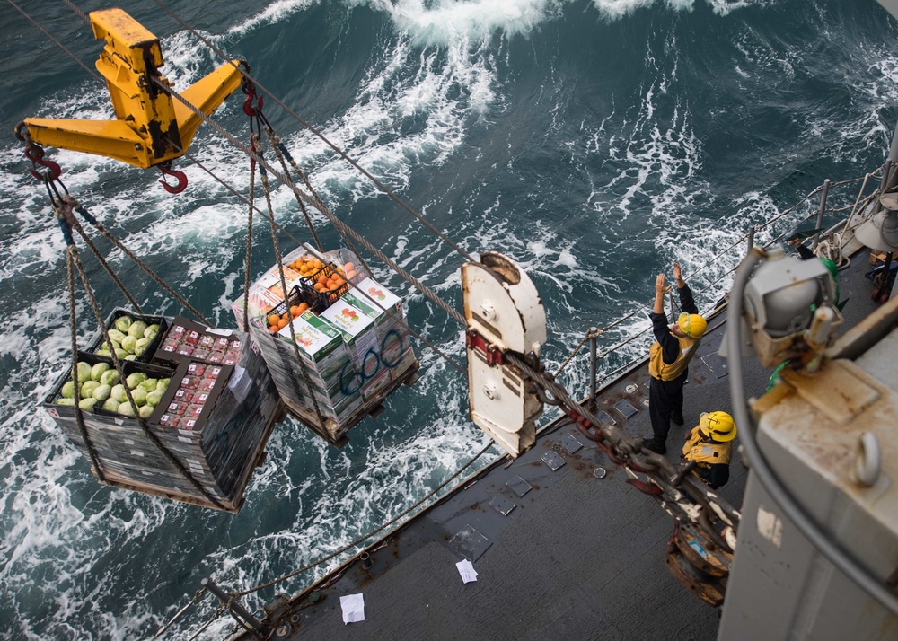 U.S. Sailors aboard the guided-missile cruiser USS Mobile Bay (CG 53), receive pallets of food during a replenishment-at-sea