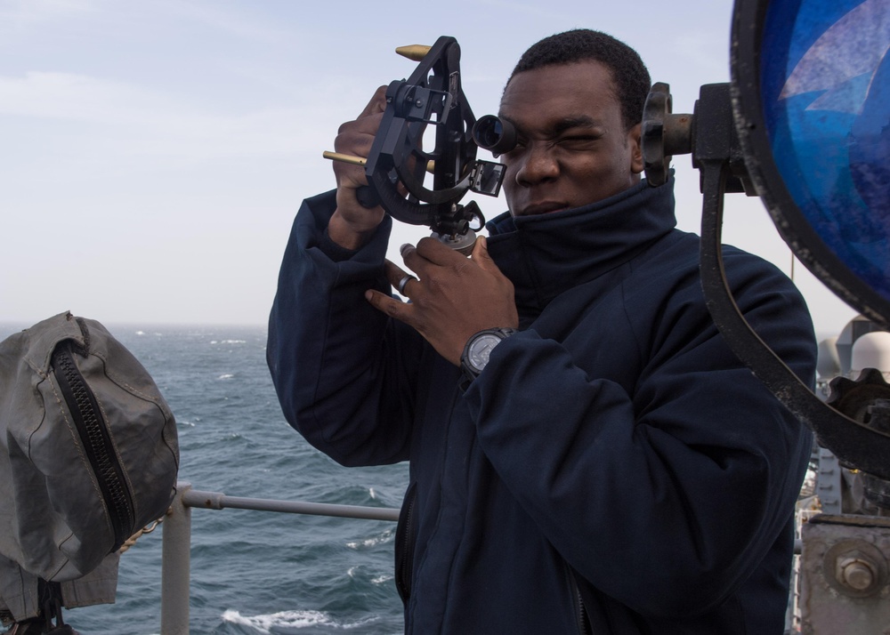 U.S. Navy Quartermaster Seaman Malich Farrell, from Miami, uses a sextant