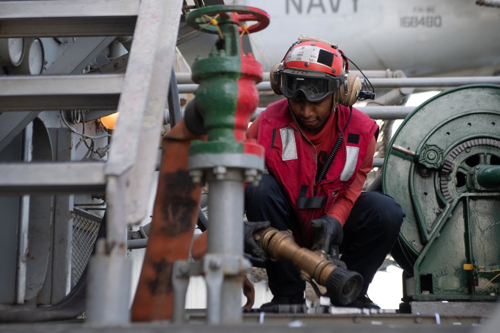 U.S. Sailor prepares an aqueous film forming foam hose