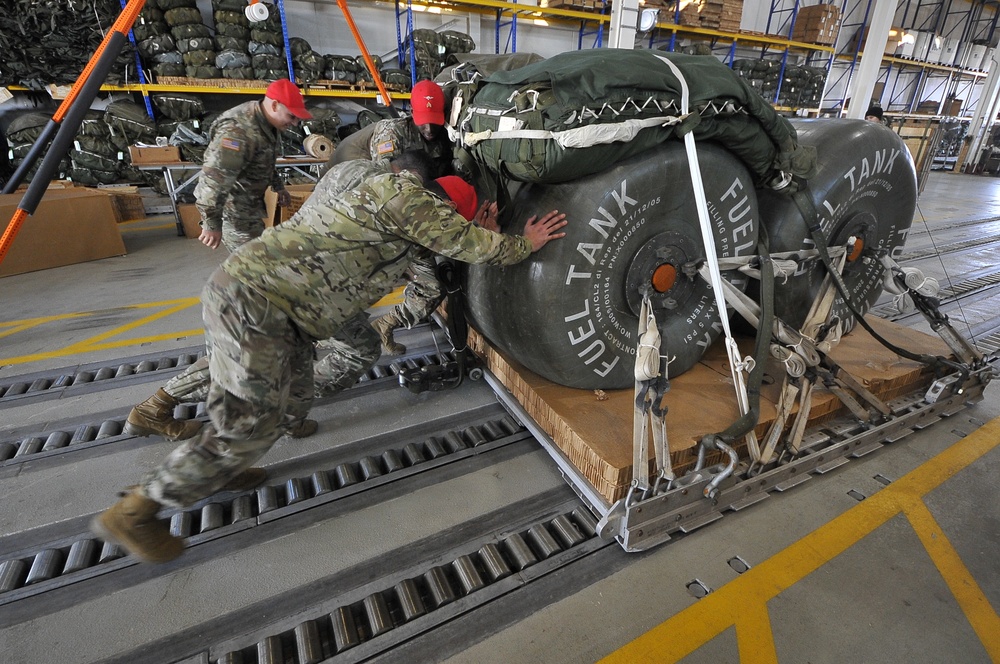 Parachute Riggers prepare fuel containers for heavy drop