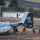 A U.S. Marines MV-22 Osprey tiltrotor aircraft belonging to VMM-266 squadron is on the ground at what appears to be a military or semi-rural airfield. Several armed Marines in combat gear are moving away from the aircraft, suggesting a tactical insertion or training exercise. The tail section prominently displays the squadron markings, tail number 8636, and a dragon/griffin emblem.