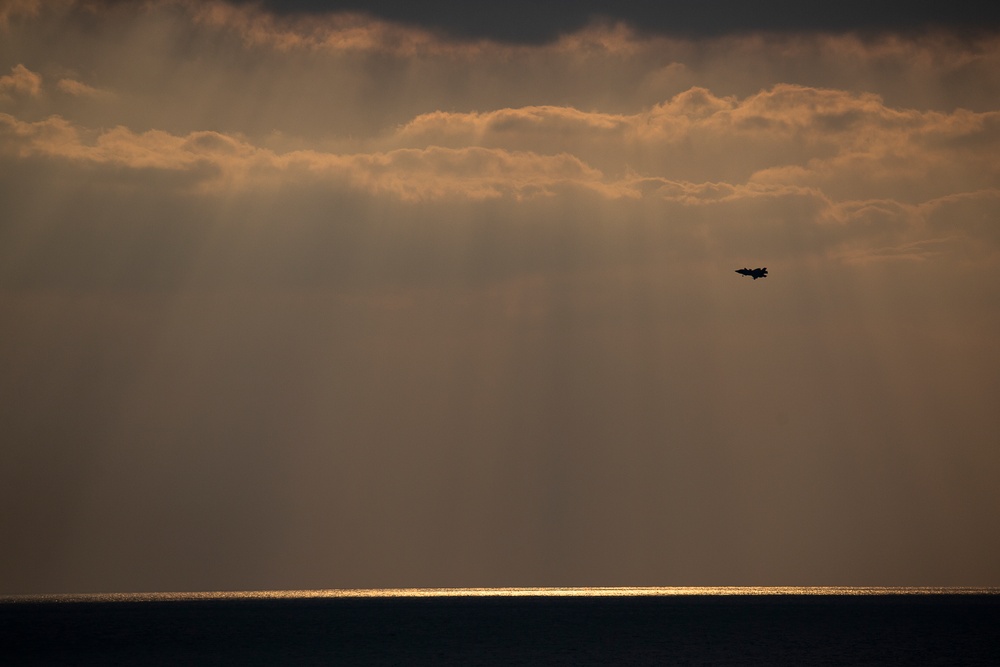 VMFA-121 naval aviators conduct flight operations at sunset aboard Wasp