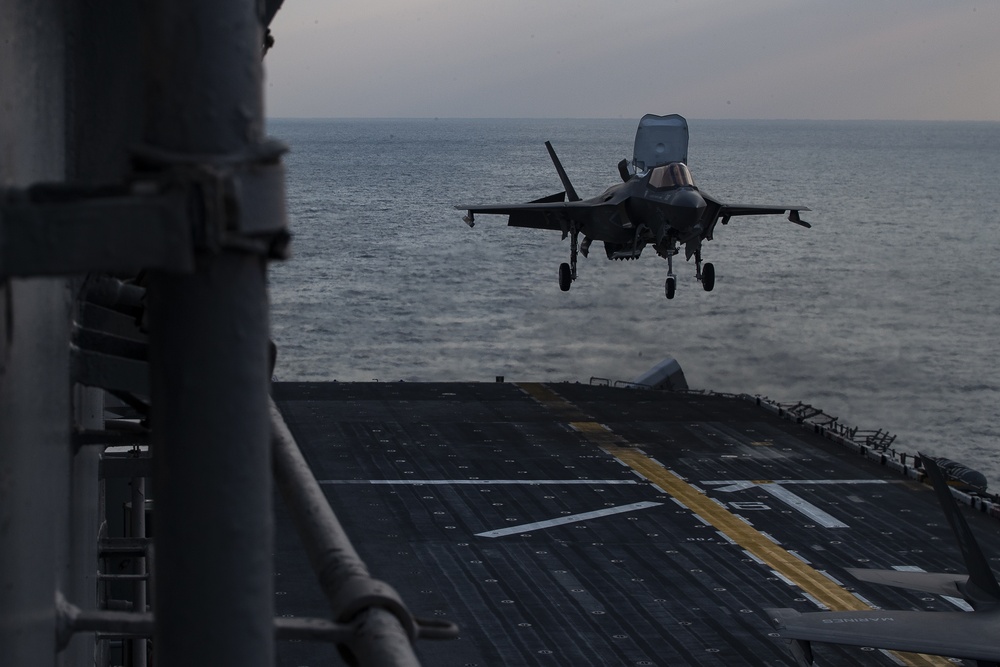 VMFA-121 naval aviators conduct flight operations at sunset aboard Wasp