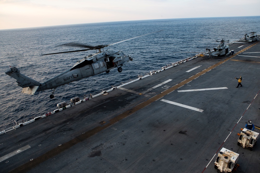 VMFA-121 naval aviators conduct flight operations at sunset aboard Wasp