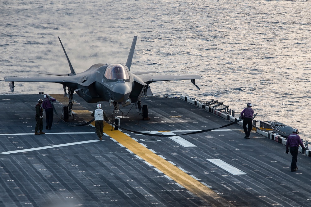 VMFA-121 naval aviators conduct flight operations at sunset aboard Wasp