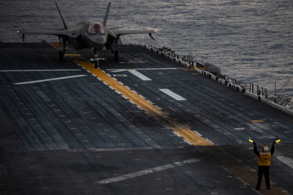 VMFA-121 naval aviators conduct flight operations at sunset aboard Wasp