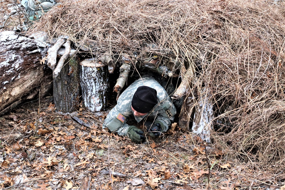 Cold-Weather Operations Course students build improvised shelters, survive outdoors