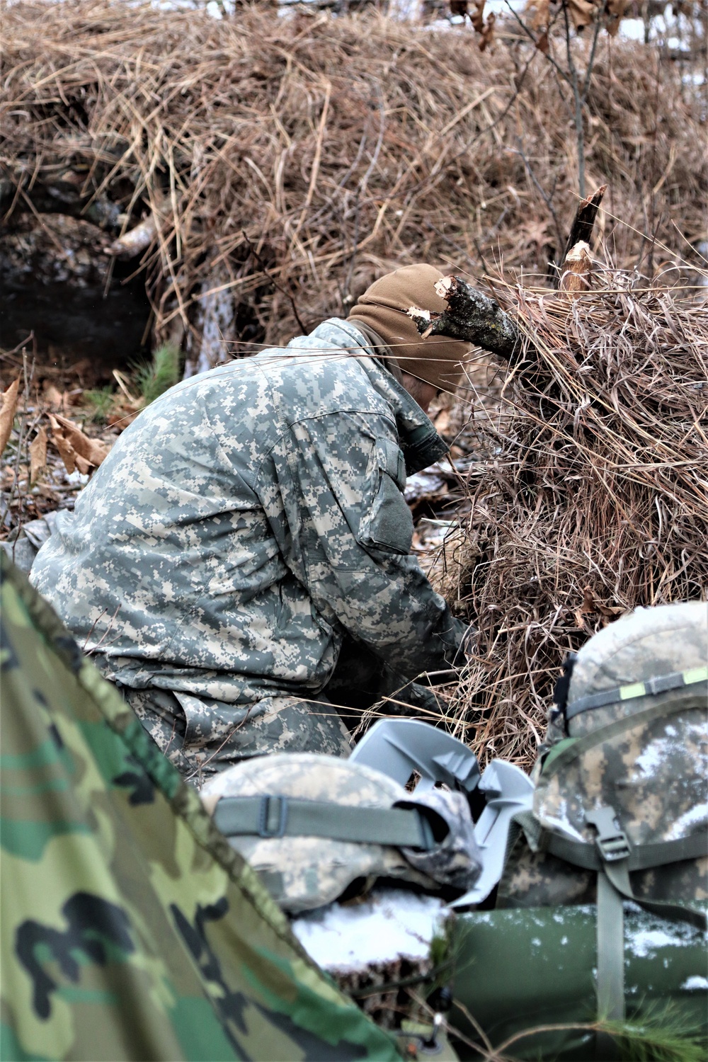 Cold-Weather Operations Course students build improvised shelters, survive outdoors