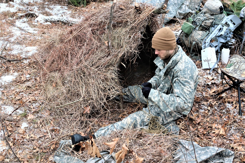 Cold-Weather Operations Course students build improvised shelters, survive outdoors