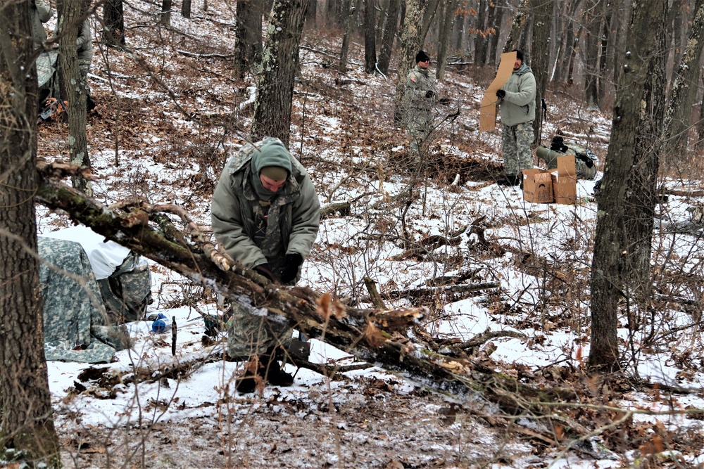 Cold-Weather Operations Course students build improvised shelters, survive outdoors