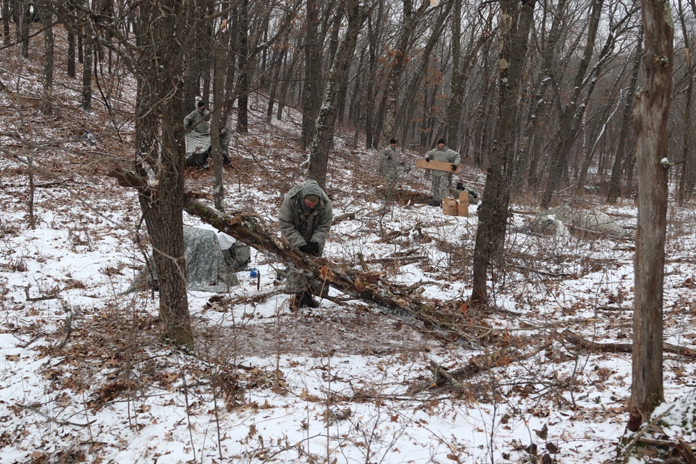 Cold-Weather Operations Course students build improvised shelters, survive outdoors