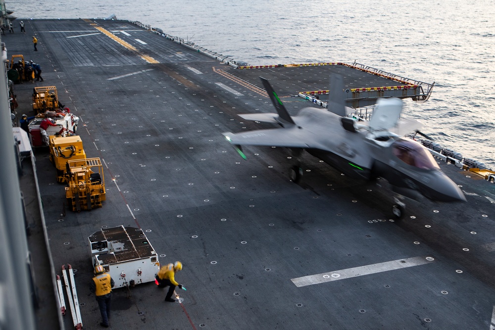 VMFA-121 naval aviators conduct flight operations at sunset aboard Wasp