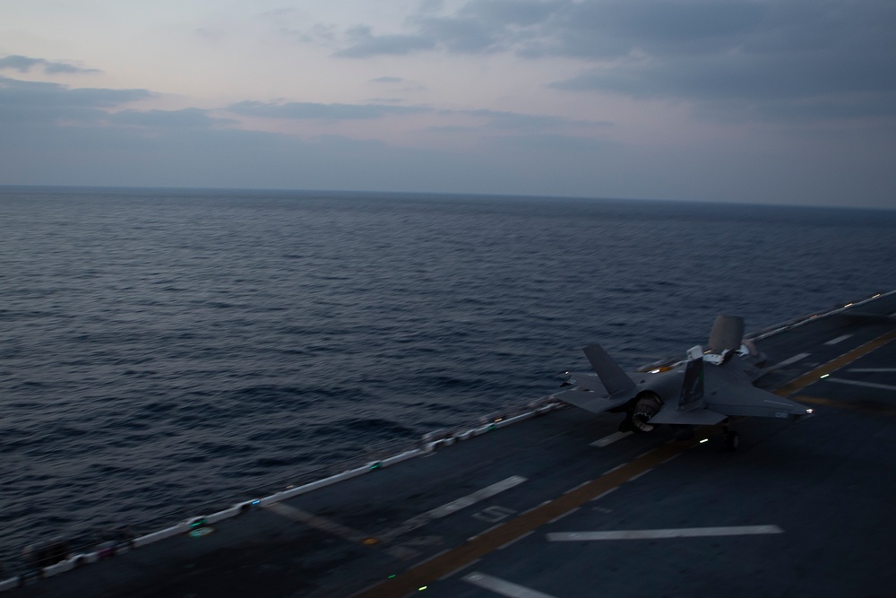 VMFA-121 naval aviators conduct flight operations at sunset aboard Wasp