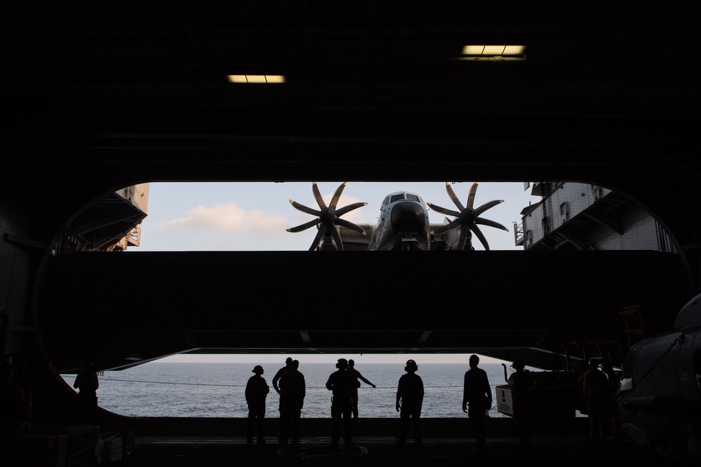 U.S. Sailors observe a C-2A Greyhound on an aircraft elevator