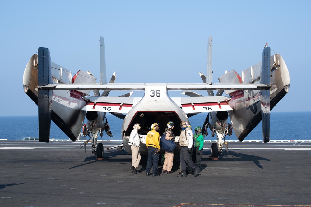 U.S. Sailors observe cargo in the cabin of a C-2A Greyhound