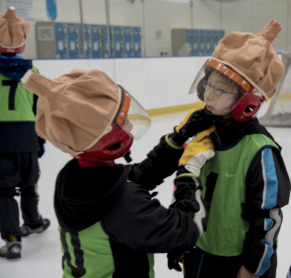 A fellow teammate adjusts the helmet before another match