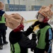 A fellow teammate adjusts the helmet before another match