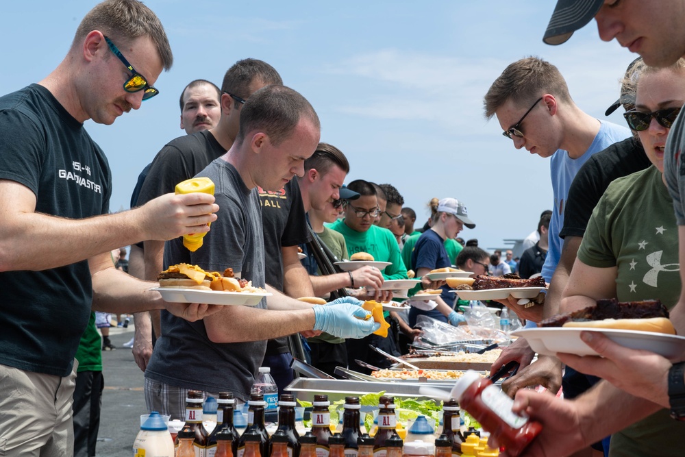 U.S. Sailors are served food during a steel beach picnic