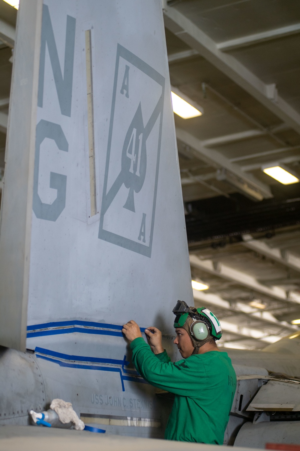 U.S. Sailor prepares to seal a vertical stabilator
