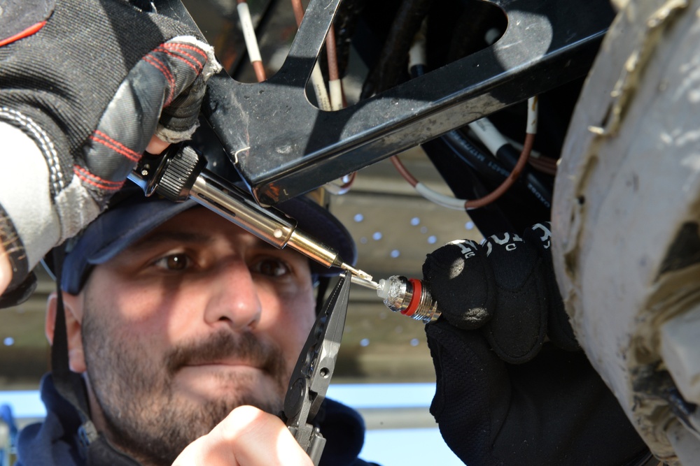 Coast Guard electronics technicians repair critical equipment aboard National Security Cutter while 147’ feet above sea level